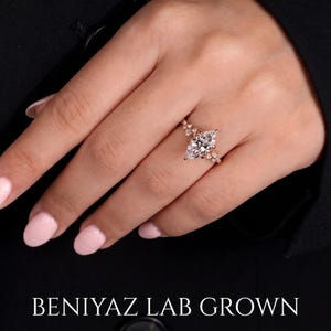 Marquise lab grown diamond engagement ring worn on hand, showing the vintage cluster design and elegant solid gold band.