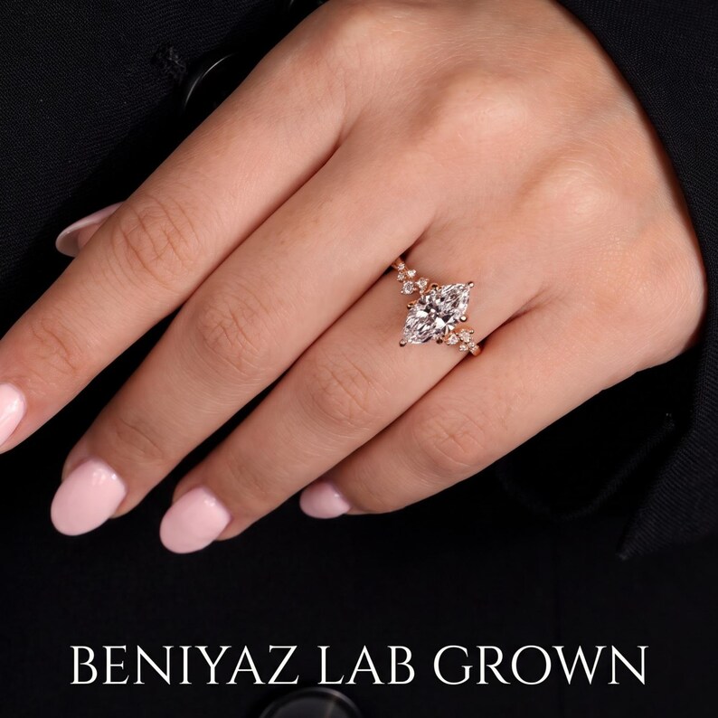 Marquise lab grown diamond engagement ring worn on hand, showing the vintage cluster design and elegant solid gold band.