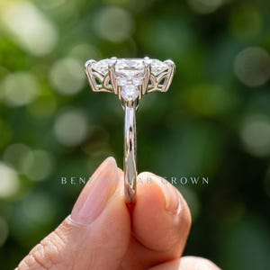 Side view of marquise engagement ring on blue velvet showing elevated center setting and decorative gallery structure