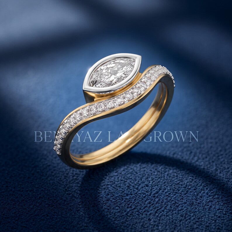Luxury marquise lab grown diamond bridal set photographed at an angle, showing the yellow gold engagement ring and matching curved diamond wedding band.