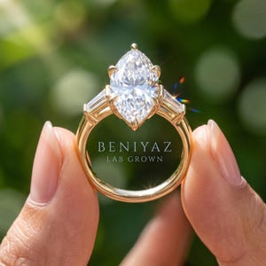 Rear view of elongated Dutch marquise engagement ring held by hand showing open gallery, prong setting and polished shank