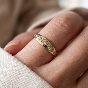Close up hand wearing a starburst diamond stacking ring with seven graduated lab grown diamonds in celestial settings