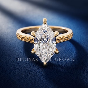 Front view of a marquise diamond engagement ring with elongated centre stone and detailed vintage inspired gold band.