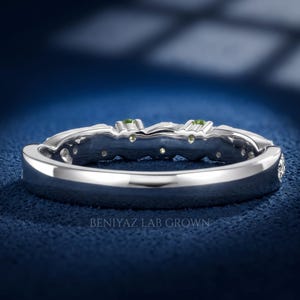 Botanical peridot ring with round gemstones prong set among sculpted leaves on a slim decorative band.