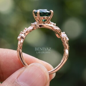 Rear and side view of nature inspired emerald ring showing raised center setting and curved botanical band design.