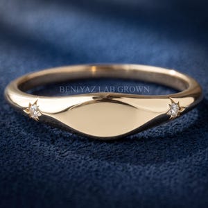 Blank personalized signet ring in yellow gold with two star-set lab grown diamonds and a smooth engraving face.