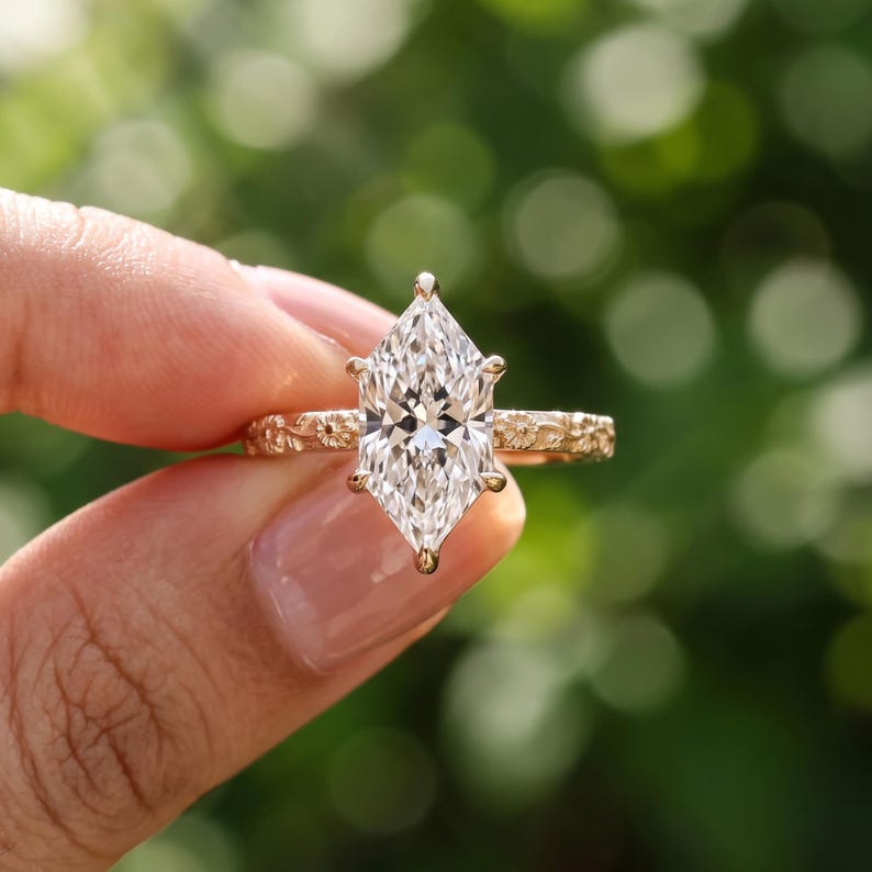 Floral engagement ring with a Dutch marquise lab grown diamond on a yellow gold band carved with daisies and vines
