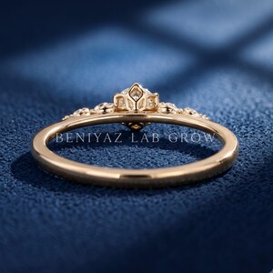 Angled side view of a five stone lab grown diamond ring with graduated round diamonds and delicate claw prong settings in yellow gold.