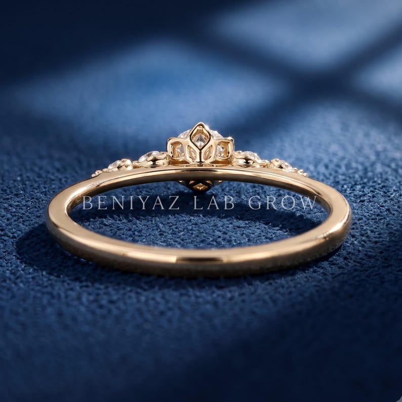 Angled side view of a five stone lab grown diamond ring with graduated round diamonds and delicate claw prong settings in yellow gold.