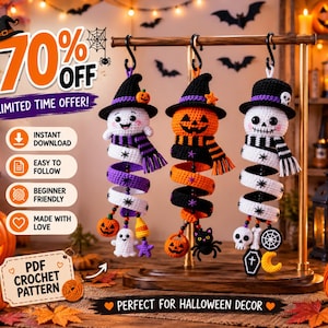 Può includere: Tre decorazioni all'uncinetto appese raffiguranti un fantasma, una zucca e uno scheletro, ognuno con un cappello da strega e una sciarpa a righe. Gli ornamenti hanno corpi a spirale decorati con piccoli ciondoli, appesi a un supporto in legno.