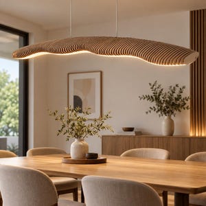 Könnte beinhalten: Eine lineare Pendelleuchte mit einer geschichteten, wellenförmigen Holzstruktur und einer integrierten Lichtquelle, die warmes Licht nach unten abgibt. Das Design besteht aus dünnen, gestapelten Lamellen, die eine organische Form bilden.