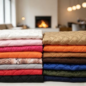 Può includere: Due pile di tessuto trapuntato piegato in vari colori, tra cui bianco, rosa, magenta, arancione, fantasia, grigio, rosso, nero, beige, marrone, blu e verde scuro. Ogni pezzo presenta un motivo a cuciture a forma di diamante.