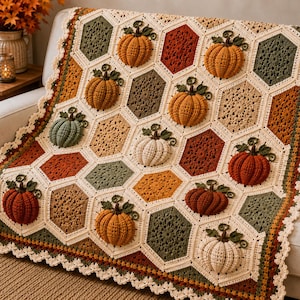 May include: A crochet blanket featuring a hexagonal pattern with alternating solid and textured motifs. The design incorporates three-dimensional pumpkins in shades of orange, green, and cream, finished with a decorative scalloped border.