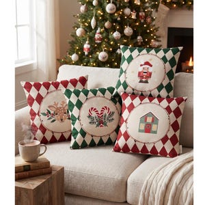 May include: Four square throw cushions featuring a diamond pattern in red, green, and white. Each cushion has a central circular medallion displaying a different holiday illustration: a nutcracker, a reindeer, candy canes, and a small house.