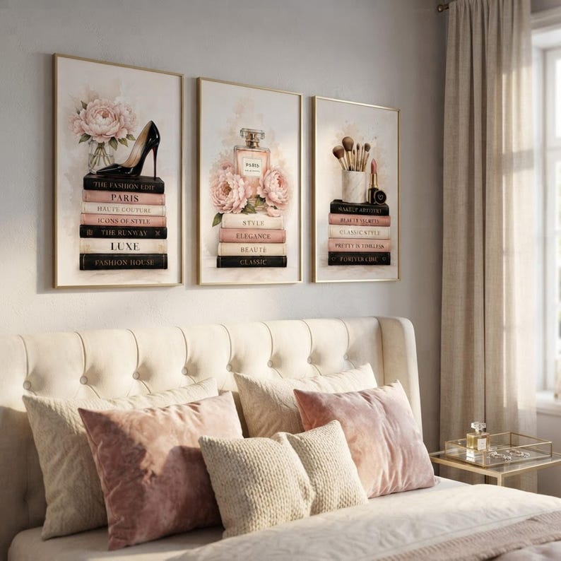 The set of three fashion wall art prints displayed above a cozy blush and cream bedroom headboard.