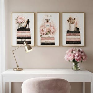 The three fashion prints displayed together on a beige accent wall in a bright, feminine home office.