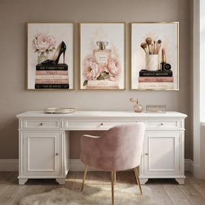 Set of 3 fashion wall art prints hanging above a chic pink and white dressing room vanity.
