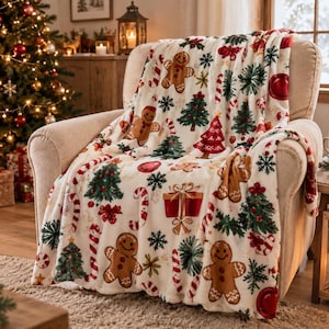Può includere: Una coperta color crema con un motivo natalizio ripetuto di omini di pan di zenzero marroni, alberi di pino verdi, bastoncini di zucchero rossi e bianchi, scatole regalo rosse con nastri dorati e fiocchi di neve verde scuro.