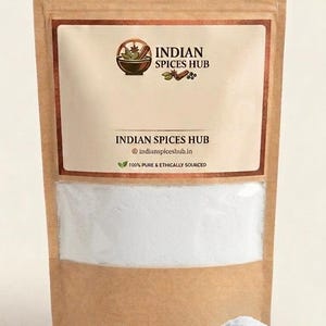 Könnte beinhalten: Ein brauner Papierbeutel mit weißem Pulver und einem Sichtfenster im unteren Bereich. Das Etikett trägt den Text INDIAN SPICES HUB, indianspiceshub.in und 100% PURE & ETHICALLY SOURCED. Ein kleiner Haufen des weißen Pulvers liegt davor.