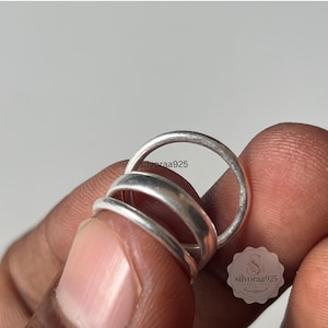 Puede incluir: Tres anillos de plata lisos con un acabado pulido y suave. Los anillos están apilados juntos, mostrando un diseño simple de banda redondeada. El texto silvoraa925 es visible en la superficie de los anillos, y un logotipo con el texto silvoraa925 está presente.