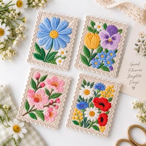 May include: Four rectangular embroidered patches with scalloped edges, each featuring distinct floral designs: a large blue daisy, a mix of yellow and purple flowers, pink cherry blossoms, and a vibrant bouquet of red, white, and blue flowers.