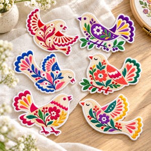 May include: Six embroidered bird patches featuring intricate floral patterns in vibrant colors including red, pink, yellow, purple, blue, and green. Each bird is depicted with detailed wing feathers and decorative botanical elements.