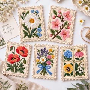 May include: Five rectangular embroidered patches with scalloped edges, each featuring different floral designs including a daisy, cherry blossoms, poppies, a mixed wildflower bouquet with a blue ribbon, and a grid of four distinct flower types.