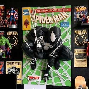 May include: A three-dimensional wall art piece featuring a black-suited Spider-Man figure crouching over a green comic book cover background. The artwork includes the text Spider-Man, All New Collectors Item Issue, and Sub-City Part One of Five.