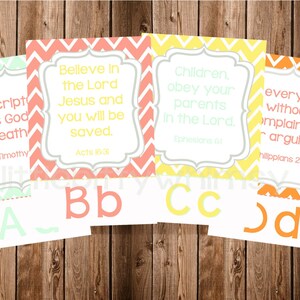 May include: Four printable cards with chevron patterns in green, pink, yellow, and orange. Each card features a Bible verse and a letter of the alphabet. The verses are: "All Scripture is God breathed", "Believe in the Lord Jesus and you will be saved", "Children, obey your parents in the Lord", and "Everything without complaining or arguing".
