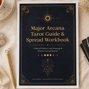 Puede incluir: Un libro de ejercicios rectangular titulado Major Arcana Tarot Guide & Spread Workbook con una cubierta azul oscuro que presenta ilustraciones celestiales doradas, fases lunares y símbolos geométricos. El texto incluye Celestial Wisdom, Card Meanings & Intuitive Journal Spreads.