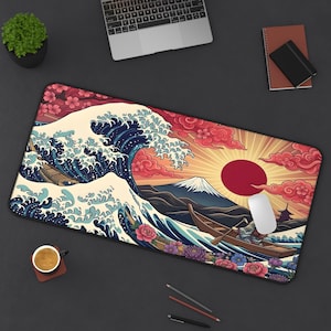 May include: A rectangular desk mat featuring a stylized illustration of a large ocean wave, a snow-capped mountain, a red sun, and a small boat with a person rowing. The design includes pink and purple floral accents and red clouds on a dark background.