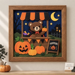 May include: A framed felt wall art piece depicting a brown bear in a vampire cape behind a stall with orange and black stripes. The scene includes jack-o'-lanterns, a crescent moon, stars, and a sign that reads PUMPKINS with a small pumpkin icon.
