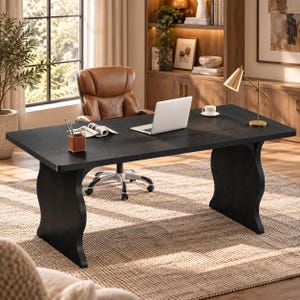 May include: A large black rectangular desk with curved side supports, featuring a silver laptop, a white ceramic cup, and a brown leather pen holder on its surface. A brown leather office chair with wheels is positioned behind the desk.