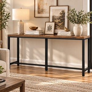 May include: A long rectangular console table featuring a dark brown wood-grain surface and a sturdy black metal frame with four legs. The table is positioned horizontally, providing a flat surface for decorative items and books in a room.