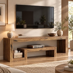 May include: A long, rectangular wooden media console with a dark brown, distressed wood grain finish. The console features an open lower shelf, a flat top surface, and a sturdy frame. It is positioned beneath a large, wall-mounted flat-screen television.