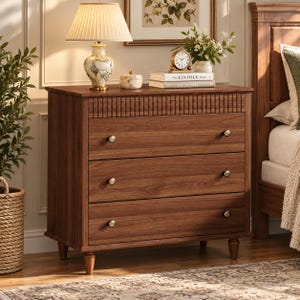 May include: A wooden three-drawer dresser with a dark brown finish, featuring a horizontal slatted design along the top drawer, four tapered legs, and small round metallic knobs on each drawer front for a clean and functional storage piece.