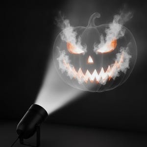 May include: A black cylindrical projector light casting a bright, focused beam that displays a glowing, orange-lit jack-o'-lantern face surrounded by swirling white smoke effects against a dark, solid background.