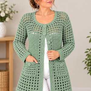 Può includere: Un cardigan all'uncinetto color verde salvia caratterizzato da un motivo traforato a griglia, maniche lunghe e scollo rotondo. Il capo presenta una chiusura frontale con tre bottoni coordinati e due tasche applicate, decorate da un bottone.