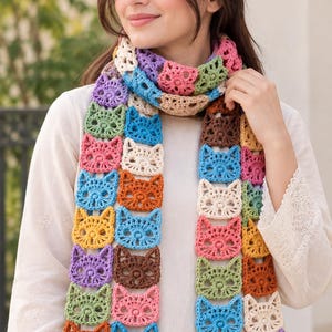 May include: A long, handmade crochet scarf constructed from a series of interconnected, multi-colored cat-shaped motifs. The scarf features a vibrant palette including shades of blue, pink, yellow, orange, purple, brown, green, and cream yarn.