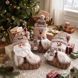 Può includere: Tre calze natalizie con motivo a venature del legno e bordo in pelliccia sintetica. Ogni calza mostra un personaggio: Babbo Natale, una renna con il nome Henry e un pupazzo di neve con il nome Emma. Il nome Neah è su Babbo Natale.