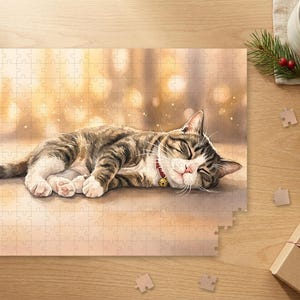 May include: A jigsaw puzzle featuring a sleeping tabby cat with white paws and a red collar with a small gold bell. The cat is lying down against a soft, warm, golden-toned background with bokeh light effects, rendered in a painterly style.