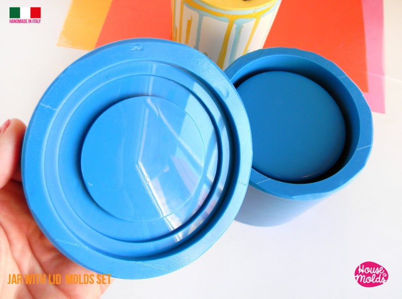May include: A blue silicone mould set for making a jar with a lid. The mould is made in Italy and is handmade. The mould is shown in two parts, the jar and the lid. The lid mould has a raised rim around the edge. The jar mould is a cylinder with a flat bottom. The mould is made of a flexible silicone material.