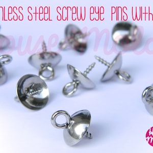 May include: Close-up of silver screw eye pins with caps. The pins have a small loop at the top and a screw thread at the bottom. The caps are round and have a smooth surface. The pins are arranged on a white surface. "House Molds" is printed in pink on the bottom right corner of the image.