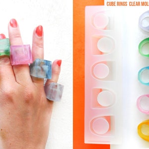 May include: Clear silicone mold for making cube-shaped rings. The mold has six cavities and is shown with finished rings in various colors, including green, blue, pink, and yellow.