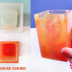 Può includere: Uno stampo in silicone rettangolare trasparente per realizzare vasi in resina. Lo stampo è mostrato con un vaso finito realizzato in resina arancione. Il testo "Handmade in Italy" e "House of Molds" è visibile nell'immagine.