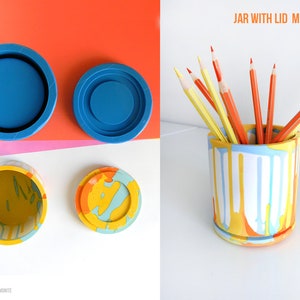 May include: A set of two blue silicone moulds for making a jar with a lid. The moulds are shown with a finished jar and lid made with resin, featuring a colourful abstract design. The jar is filled with pencils. The image also includes the text "JAR WITH LID MOLDS SET" and "House Molds".