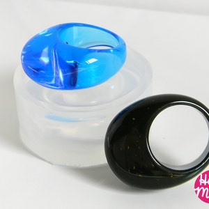 May include: Two resin rings, one blue and one black, in silicone molds. The blue ring is in a clear mold and the black ring is on a white surface. The text "House of Molds" is visible in the lower right corner of the image.