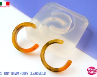 May include: Clear silicone mold for making 19 mm hoop earrings. The mold is shown with two finished earrings, one orange and one yellow.