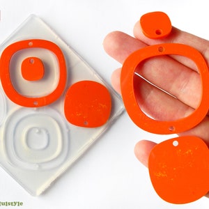 Puede incluir: Un juego de cuatro moldes de resina naranja para hacer joyas. Los moldes tienen forma de círculo, cuadrado y dos óvalos de diferentes tamaños. Los moldes están hechos en Italia.