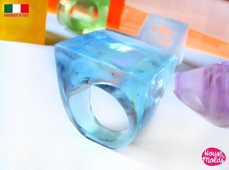 May include: A light blue, square-shaped resin ring with a clear, translucent finish. The ring is handmade in Italy.